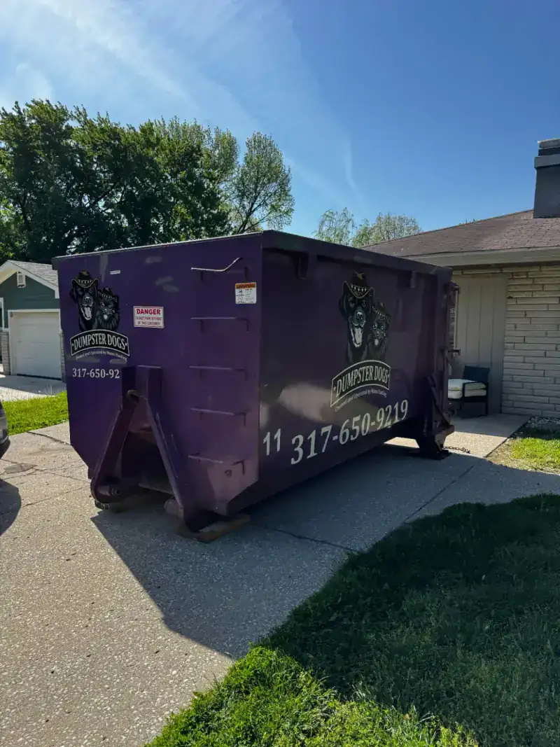 Dumpster Dogs purple roll-off dumpster on residential driveway in Indiana